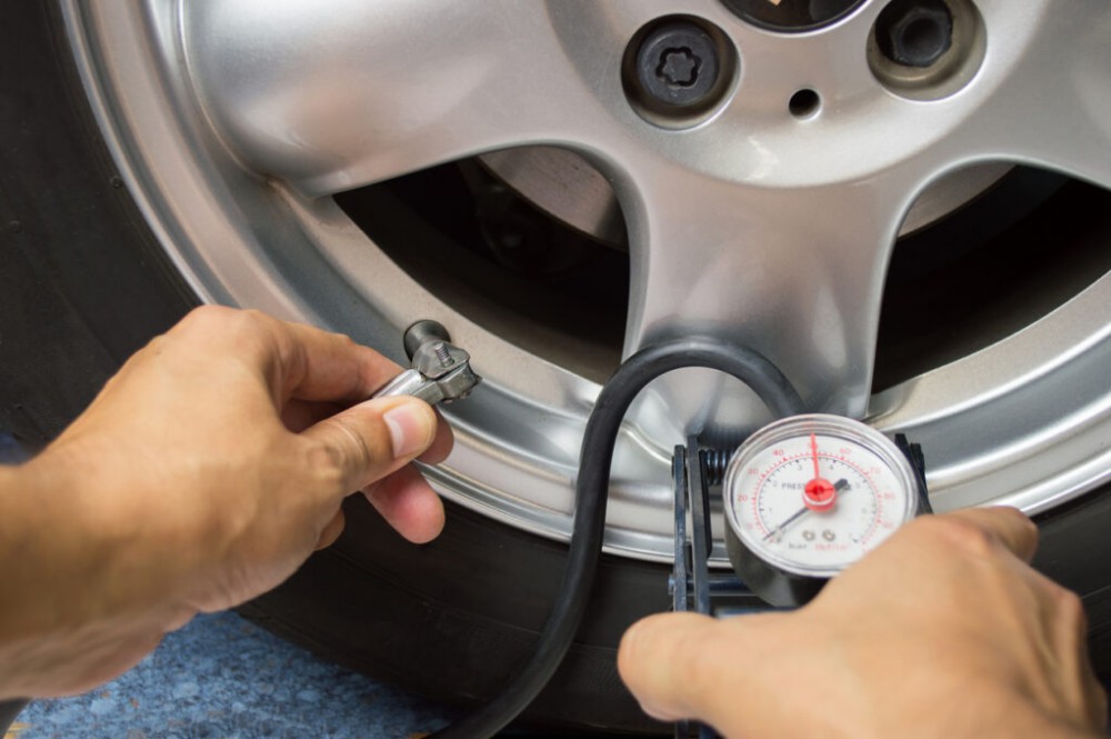 hand and car wheel add air pressure