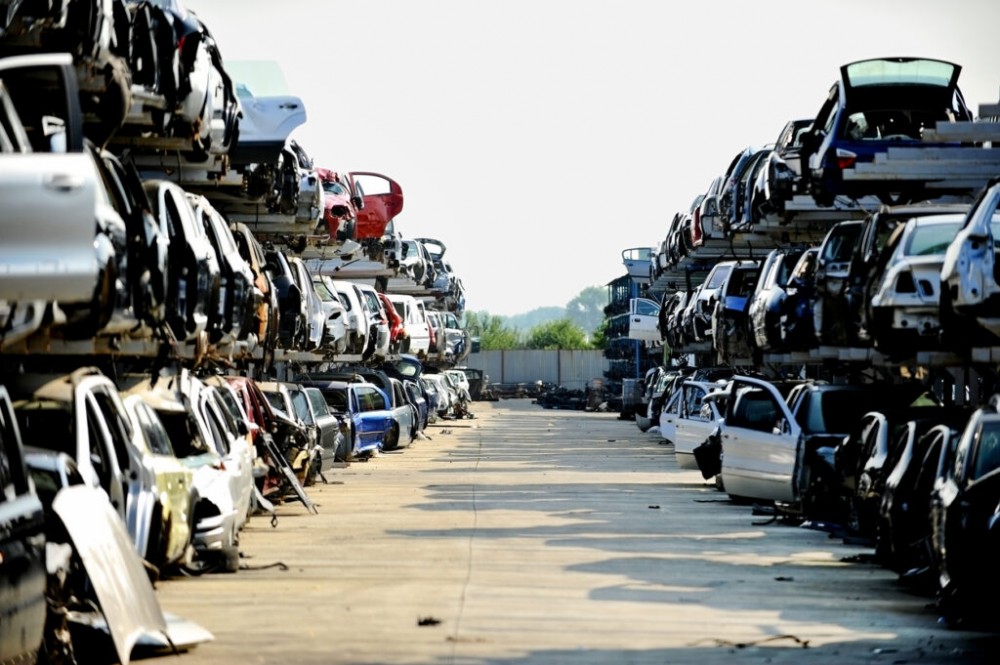 Wrecked vehicles are seen in a car junkyard